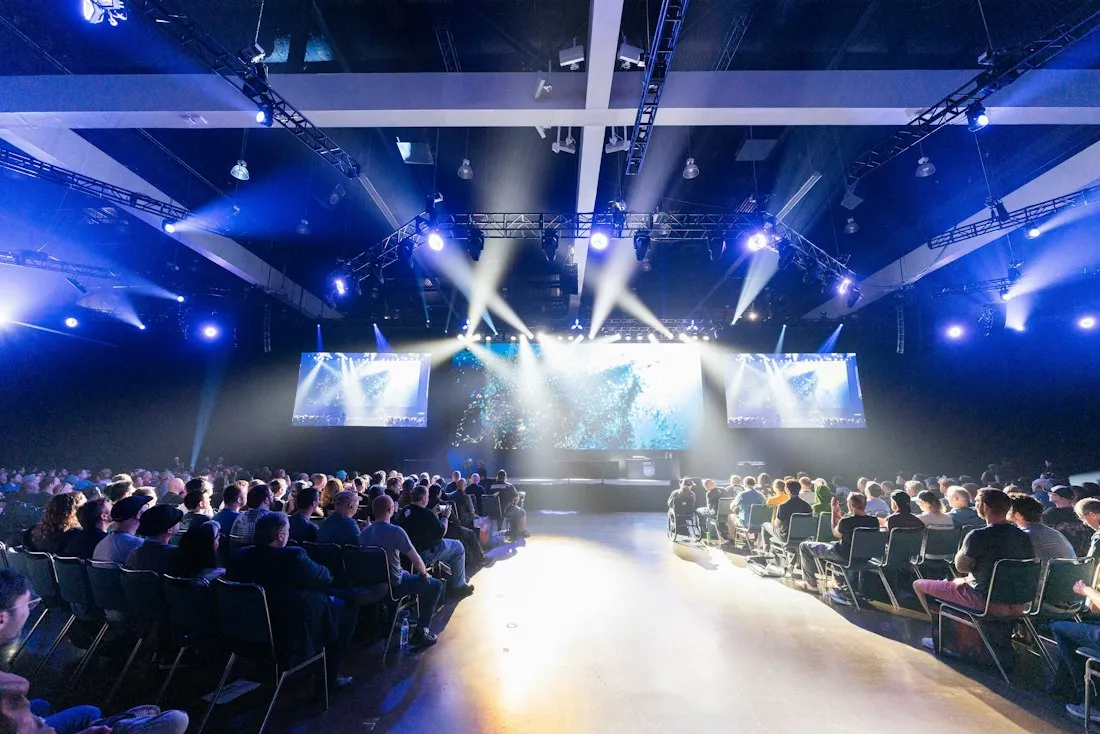 Audience in front of a lit stage at a launch event