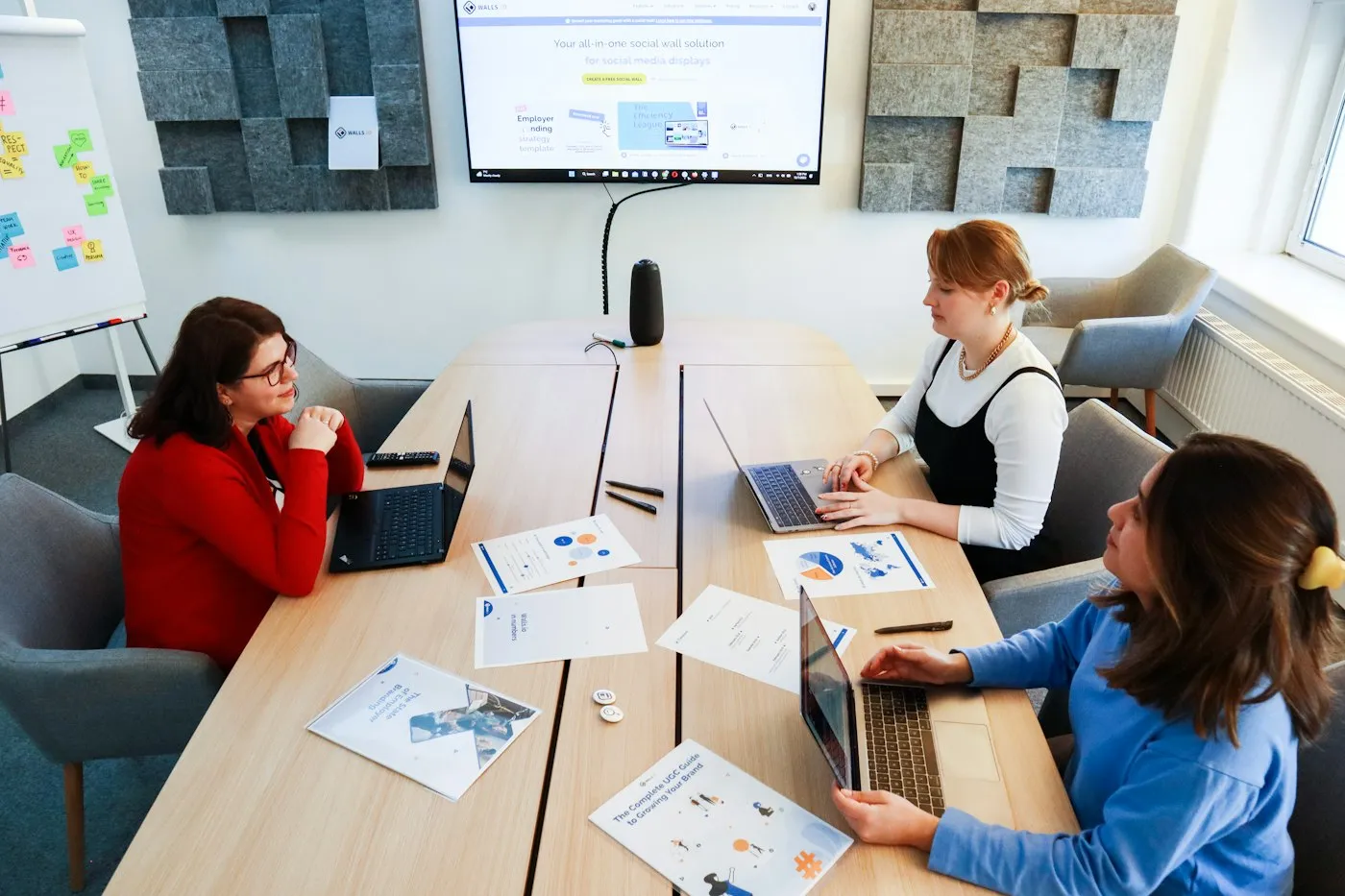 Marketing team working on laptops in a meeting room